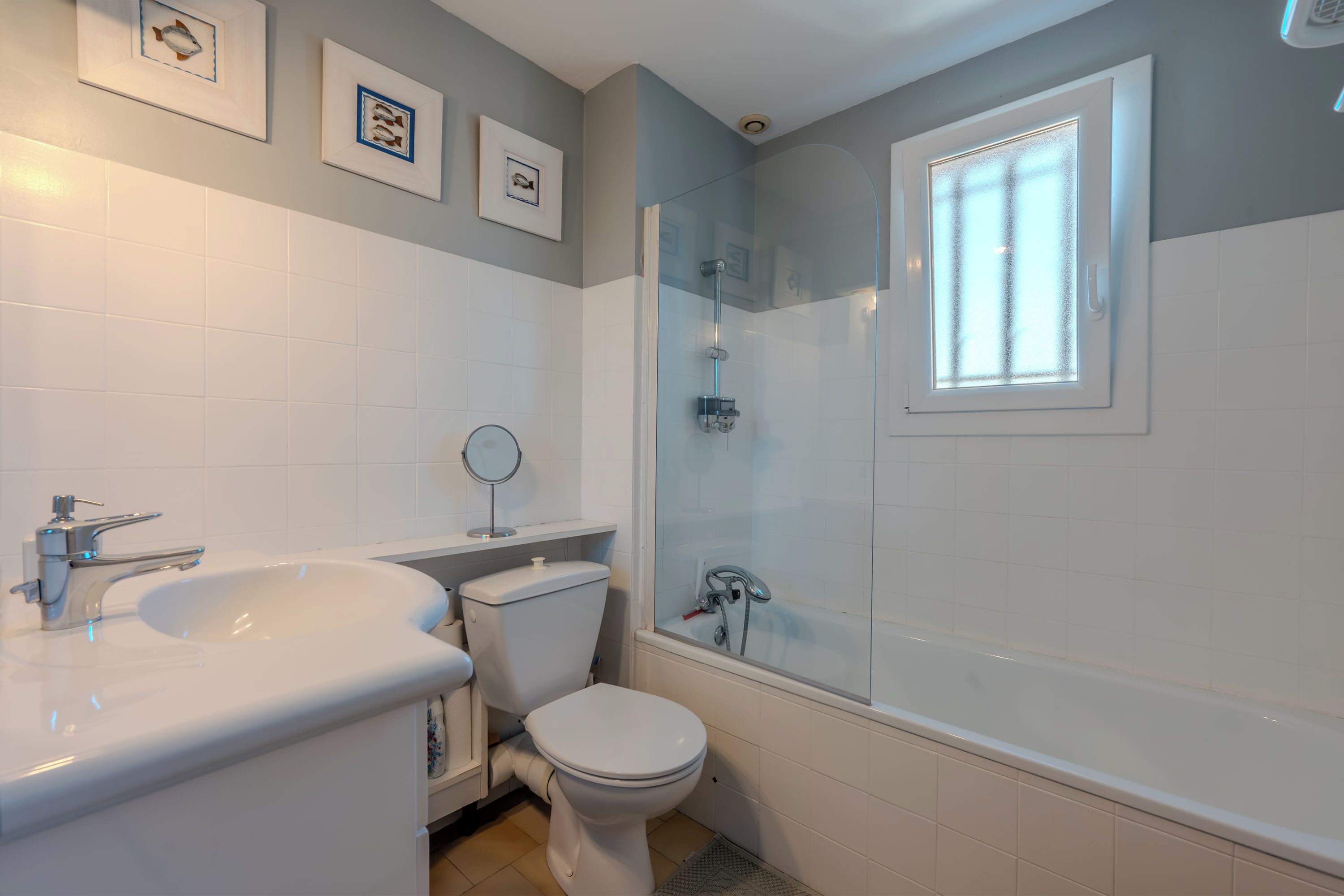 A bathroom with a bathtub, toilet, sink, and a shower area.