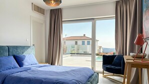 A bedroom with a bed, a desk, a chair, and a view of a building through a glass door. - Gorgeous home in Sveti Lovrec (Sveti Lovrec)