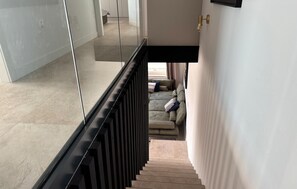 Ein modernes Interieur mit einer Treppe, die zu einem Wohnbereich mit einer Couch und Kissen führt.