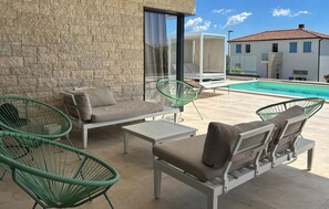 A patio with outdoor furniture, a swimming pool, and a stone wall. - Gorgeous home in Sveti Lovrec (Sveti Lovrec)
