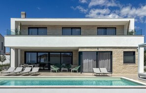 A modern two-story house with a swimming pool, outdoor seating, and large windows. - Gorgeous home in Sveti Lovrec (Sveti Lovrec)