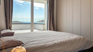 A bedroom with a large bed, a view of the sky and buildings, and a balcony. - Gorgeous home in Sveti Lovrec (Sveti Lovrec)
