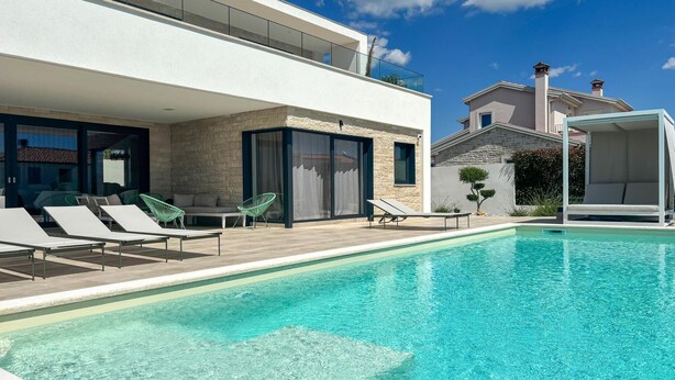 A modern pool area with lounge chairs and a clear blue pool. - Gorgeous home in Sveti Lovrec (Sveti Lovrec)