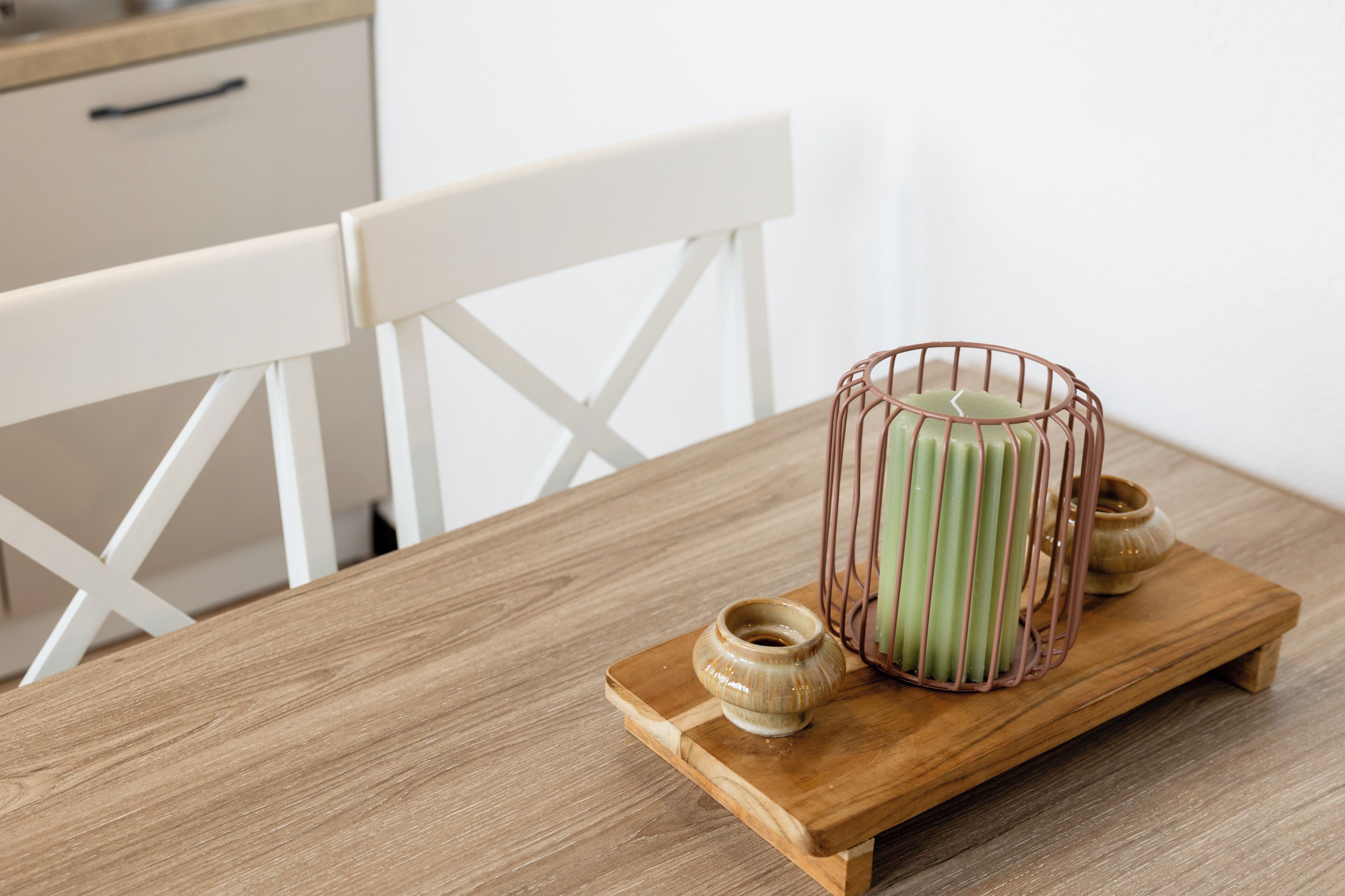 Una mesa de madera con un candelabro y un jarrón pequeño.