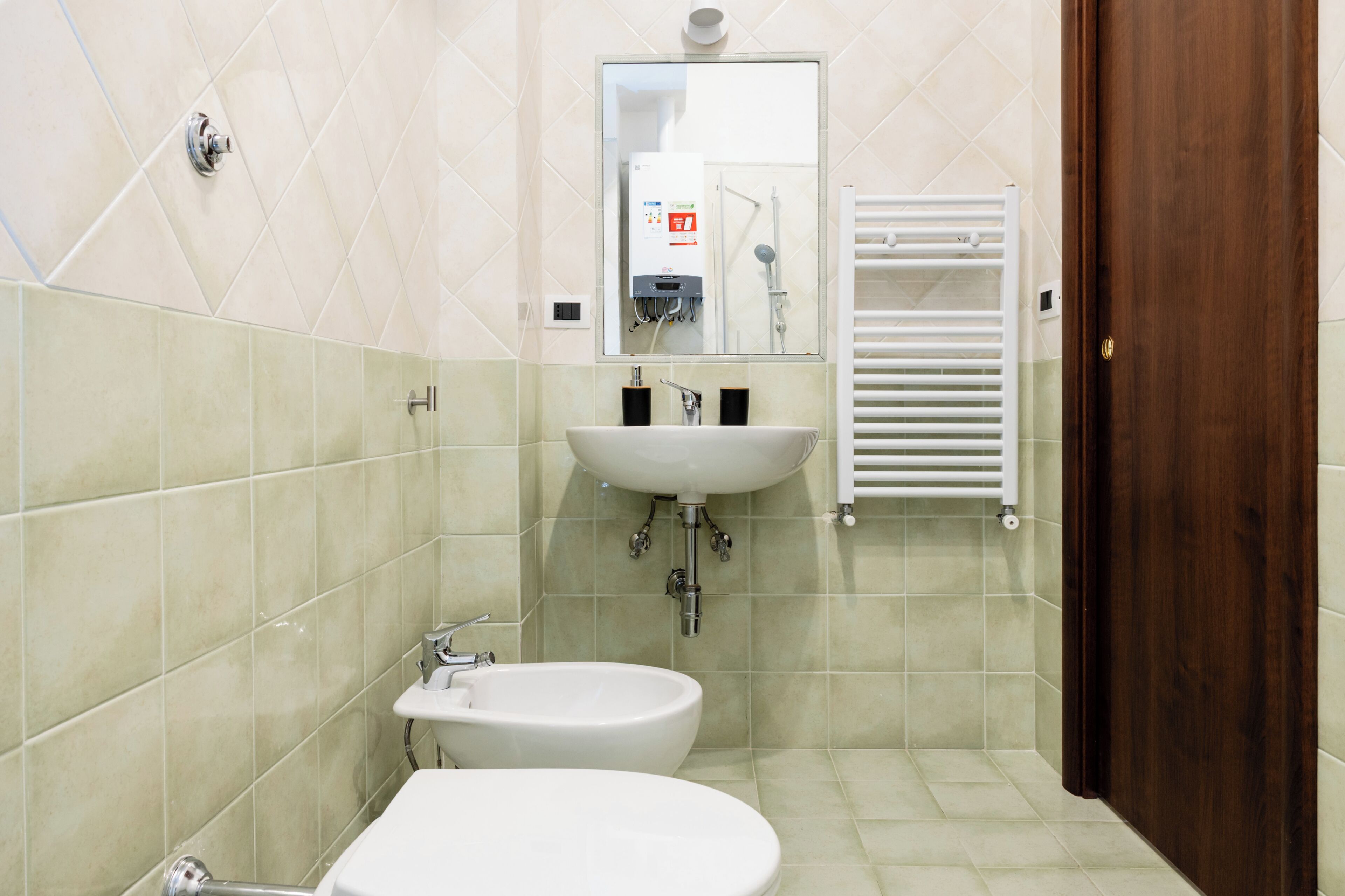 A bathroom with a sink, bidet, and toilet.