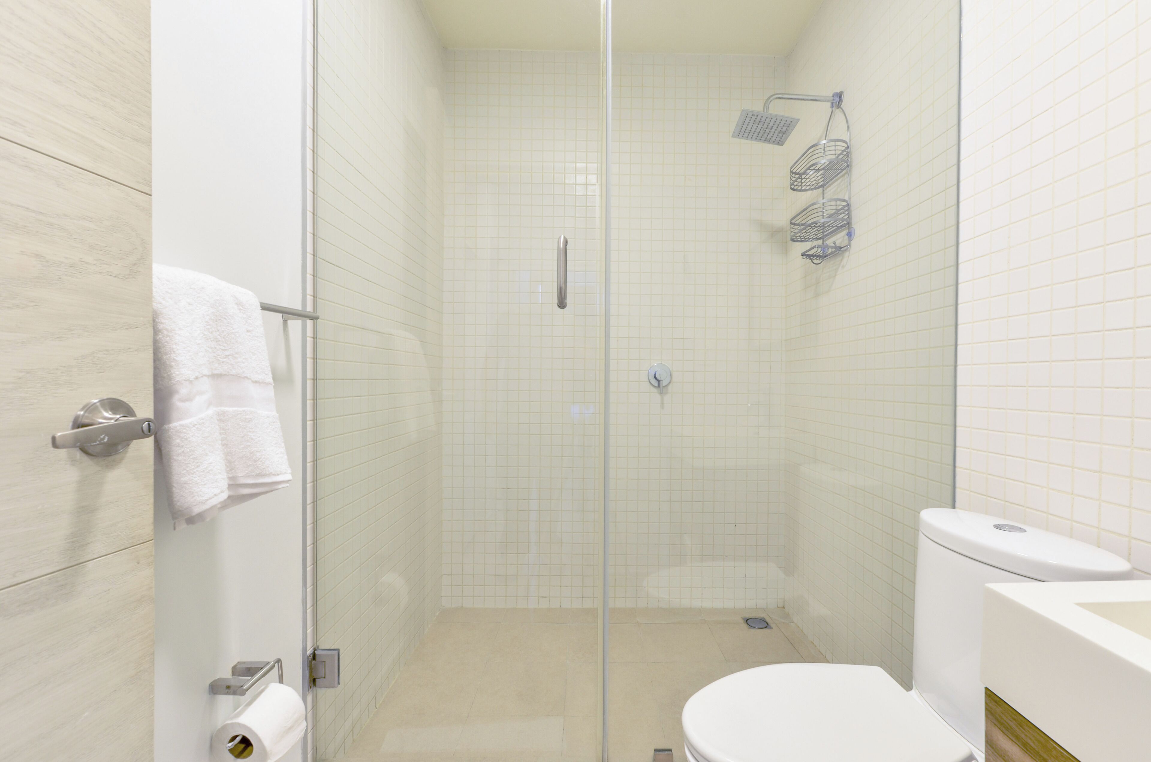 Un baño moderno con ducha de vidrio, inodoro y lavamanos.