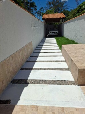 Un sendero de concreto que lleva a un edificio con techo de tejas.