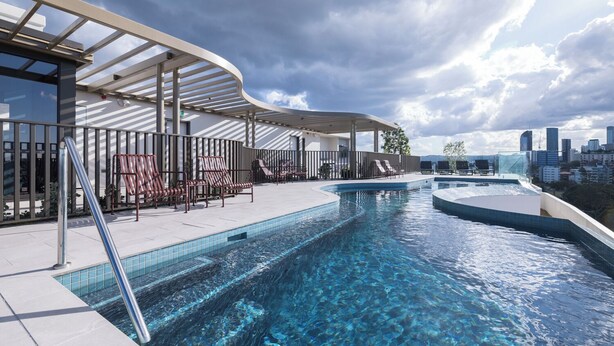 Piscina no terraço com água azul cristalina, espreguiçadeiras e vista para o horizonte da cidade.