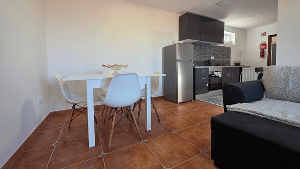 A compact living space with a kitchenette, a dining area with a white table and chairs, and a sofa. - Elena's corner (Funchal)