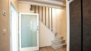 A staircase with a glass door leading to a room.