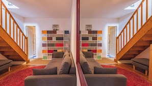 A mirrored view of a living room with a sofa, a bookshelf, and a staircase. - Unusual bubbles (Reims)