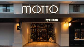 Entrada de un hotel con un llamativo letrero 'MOTTO by Hilton'.