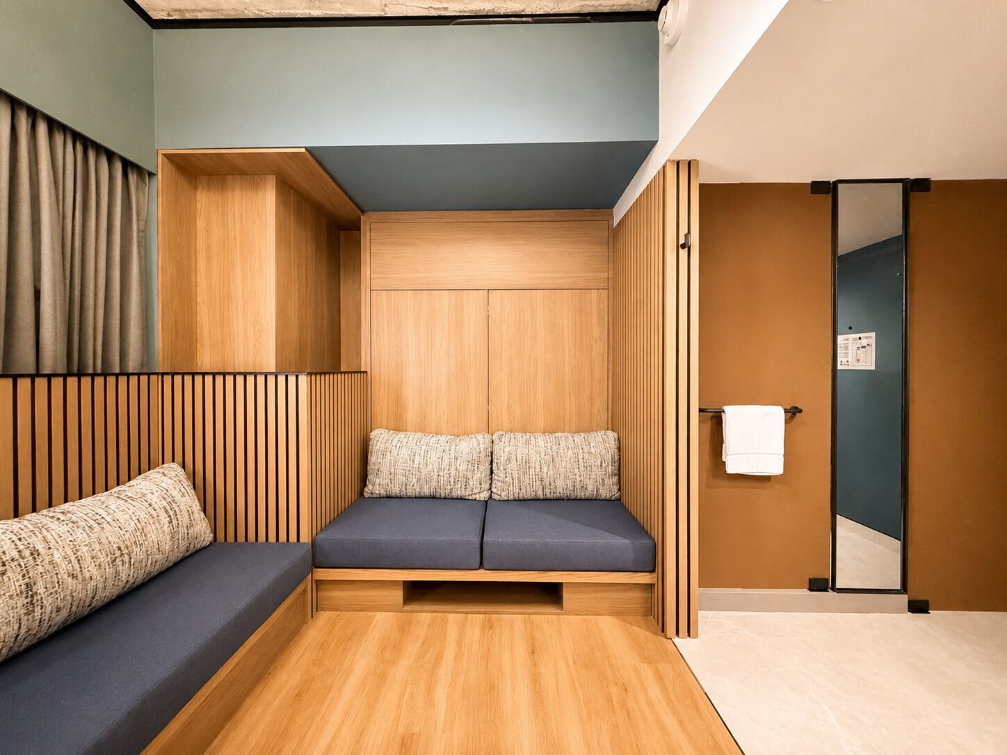 A modern room with a built-in bench, wooden paneling, and a towel rack.