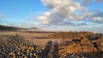A rocky beach with a distant mountain and ocean view.