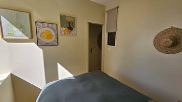 Un dormitorio con cama, puerta y decoración en la pared.