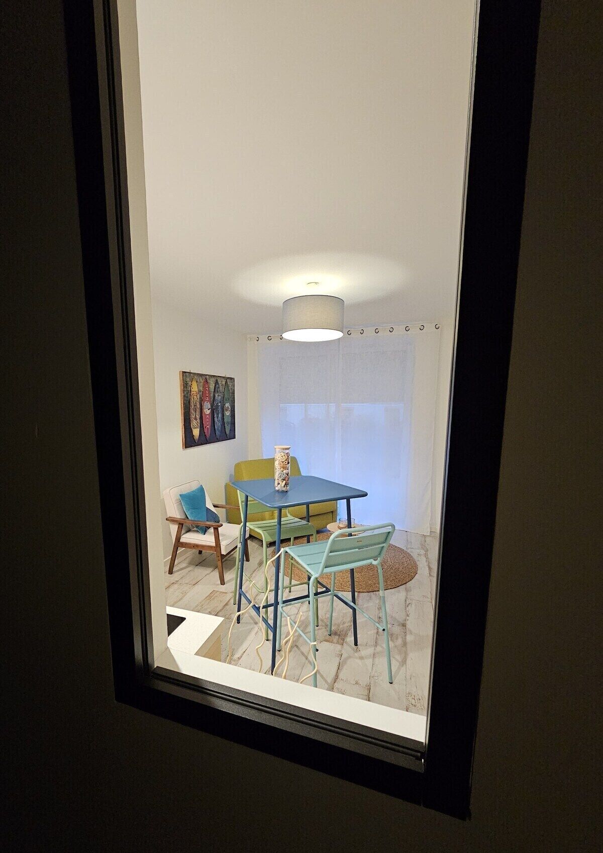 Une pièce comprenant une table à manger, des chaises, un vase et un tableau accroché au mur.