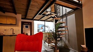 A modern interior with a red sofa, a staircase, and a potted plant. - Le Chalet-Loft-Private Bathroom-Apartment-Garden view (Genas)