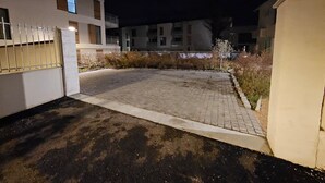 A paved driveway leading to a gated entrance of a building with multiple windows and balconies. - Le Chalet-Loft-Private Bathroom-Apartment-Garden view (Genas)