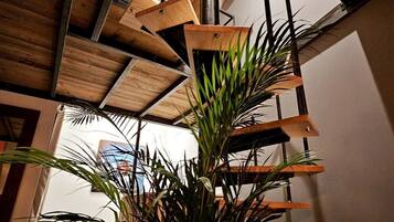 Een modern interieur met houten balken en een plant op de voorgrond.