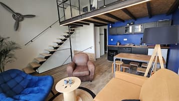 Un apartamento loft moderno con escaleras, una cocina y zonas de estar.