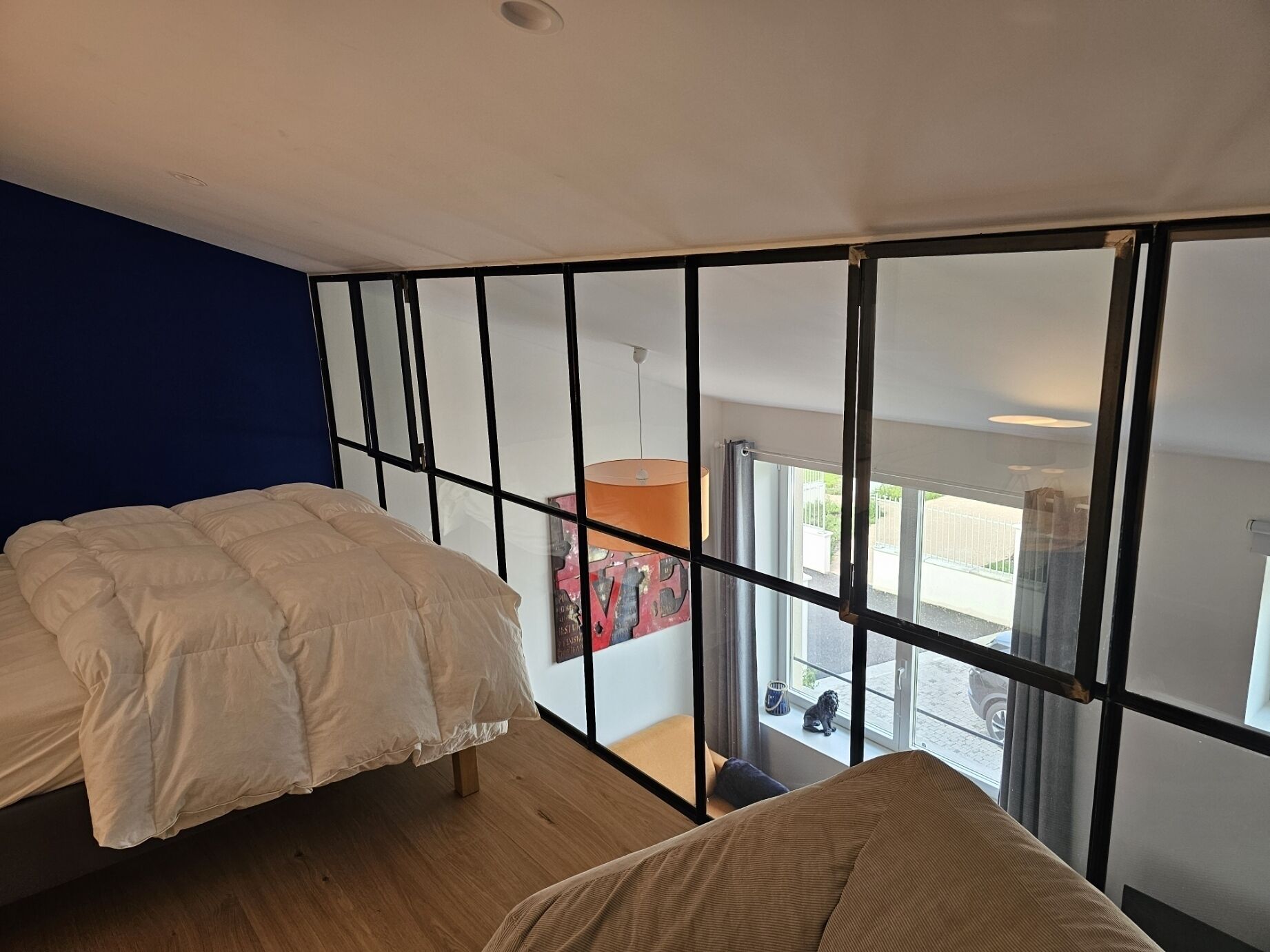 Un dormitorio con cama, ventana y vista al exterior.