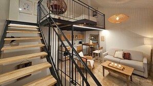Un intérieur moderne avec un escalier en colimaçon, un canapé, une table basse et un coin repas.