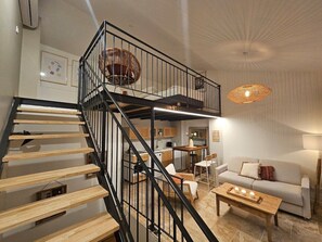 Un intérieur moderne avec un escalier en colimaçon, un canapé, une table basse et un coin repas.