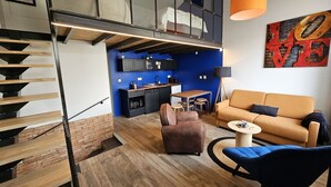 Un appartement moderne comprenant une cuisine, un espace de vie et un escalier.
