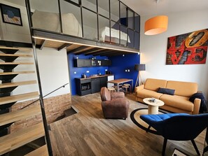 Un appartement moderne comprenant une cuisine, un espace de vie et un escalier.