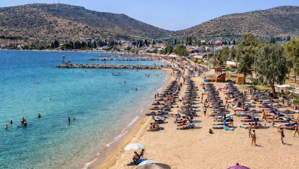 A beach with clear blue water, sun loungers, umbrellas, and a mountainous backdrop. - Byzantine Vibe - Seaside Cozy Stay Near Volos (Volos)