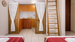 A room with two beds, a kitchen area, a wooden ladder, and a clock on the wall. - Byzantine Vibe - Seaside Cozy Stay Near Volos (Volos)