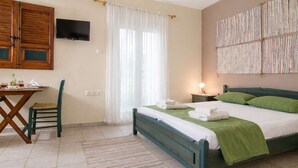 A bedroom with a bed, a desk, a chair, a TV, and a window with curtains. - Village Vibe - Seaside Stay w Balcony Near Volos (Volos)