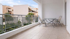 A balcony with a table and chairs, a metal railing, and a view of neighboring buildings. - Village Vibe - Seaside Stay w Balcony Near Volos (Volos)
