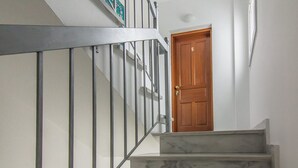 A staircase with a marble finish, a wooden door with the number 5, and a metal railing. - Village Vibe - Seaside Stay w Balcony Near Volos (Volos)
