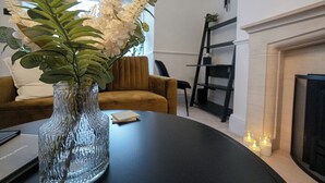 En stue med frit vue til en pejs, en sofa og et sofabord.