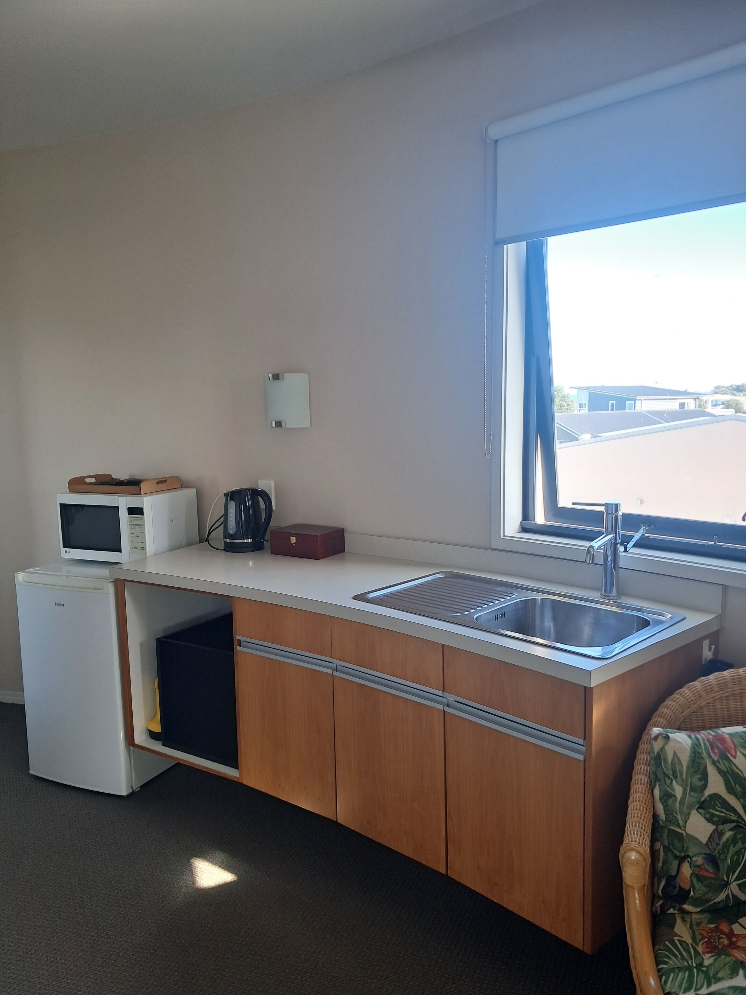 A compact kitchenette with a microwave, coffee maker, and a small refrigerator.