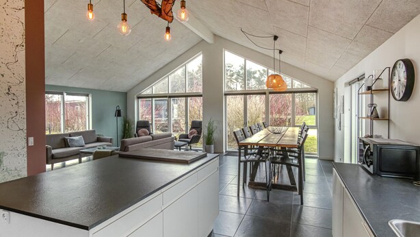 A spacious kitchen with a large island, a dining area with a long table, and a living area with a sofa and chairs. - Lovely home in Glesborg with WiFi (Glesborg)