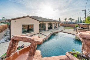 A residential backyard with a swimming pool, a patio area, and a small building with a tiled roof. - Spacious Single-Level Pool House Newly Remodeled Convenient Located 2,100 sqft+ (West Covina)