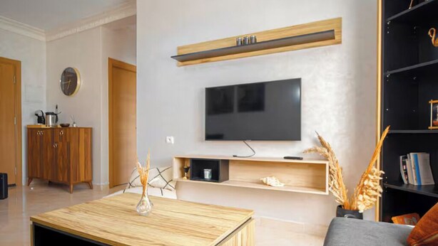 A modern living room with a flat-screen TV, wooden coffee table, and a grey sofa. - Peaceful place near stadium and airport (Tanger)