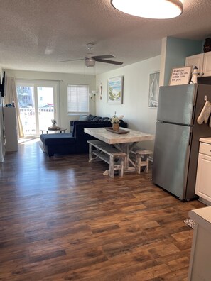 A modern kitchen with a built-in refrigerator, a dining table with benches, and a ceiling fan. - Young's Plantation Paradise-steps away from beach (Gulf Shores)