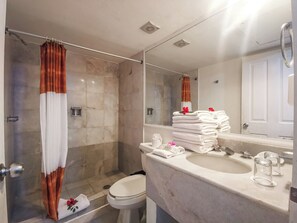 A bathroom with a shower, toilet, sink, and a mirror. - Condominios Torre Continental Ixtapa (Ixtapa)
