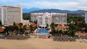 A resort with multiple hotel buildings, a central swimming pool, and a beach area. - Condominios Torre Continental Ixtapa (Ixtapa)