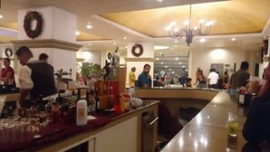 A hotel lobby with a bar area, multiple seating arrangements, and a chandelier. - Condominios Torre Continental Ixtapa (Ixtapa)
