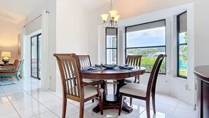 Un coin repas avec une table ronde, des chaises et un lustre.