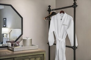 A bathroom with a mirror, a towel rack with a white bathrobe, and toiletries on a tray. - 2 Connecting Suites at a  Hotel (Los Angeles)