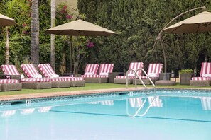 A poolside area with lounge chairs and umbrellas.