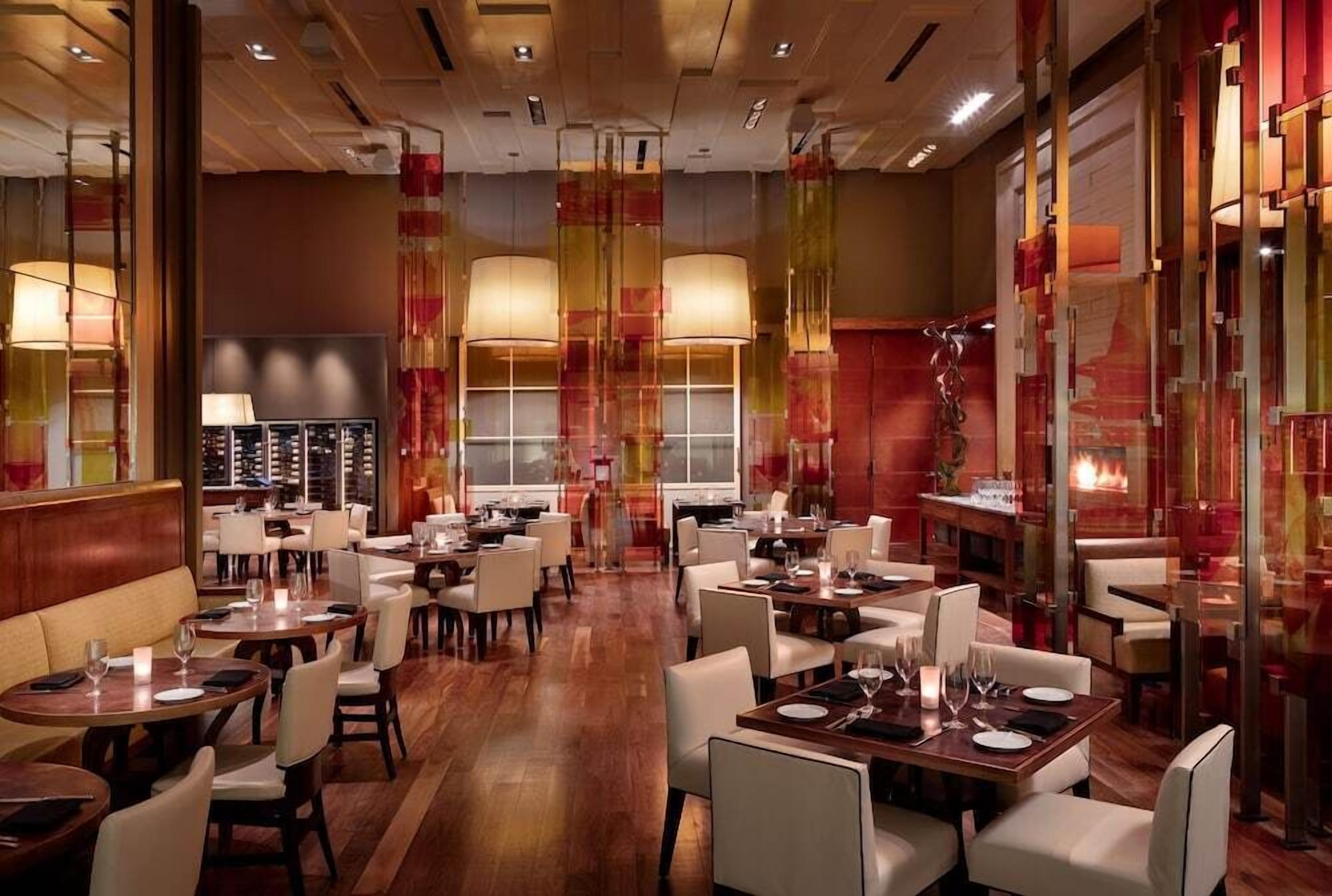 Un restaurant doté de plusieurs tables, de chaises et d’un élément décoratif central.