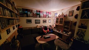 A cozy living room with a sofa, a coffee table, and a bookshelf filled with books and decorative items. - Apartment Medio in Bardu (Bardu)