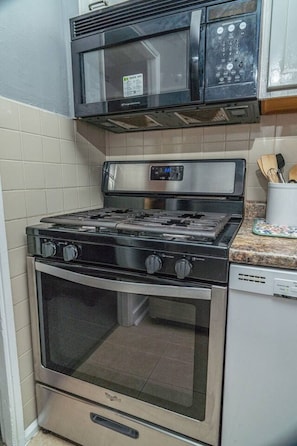 A kitchen with a stainless steel stove, oven, and microwave.