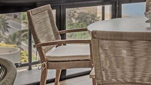 A room with a large window overlooking a beach, wicker furniture, and a view of the ocean. - Summer Cove - Beachfront with Pool (Sunshine Coast)